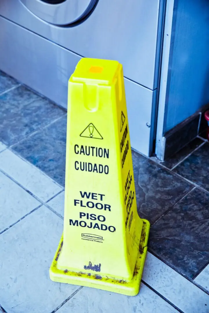 A yellow caution sign on the floor of a building.